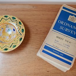 close-up view of an ornately decorated bowl beside an old ordnance survey map