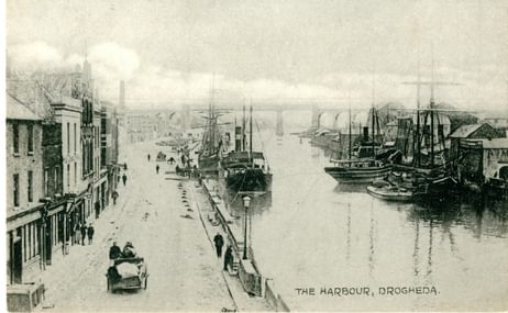 A black and white photograph of a river next to a road in 1953