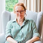 Nina Swann sitting in a chair smiling.