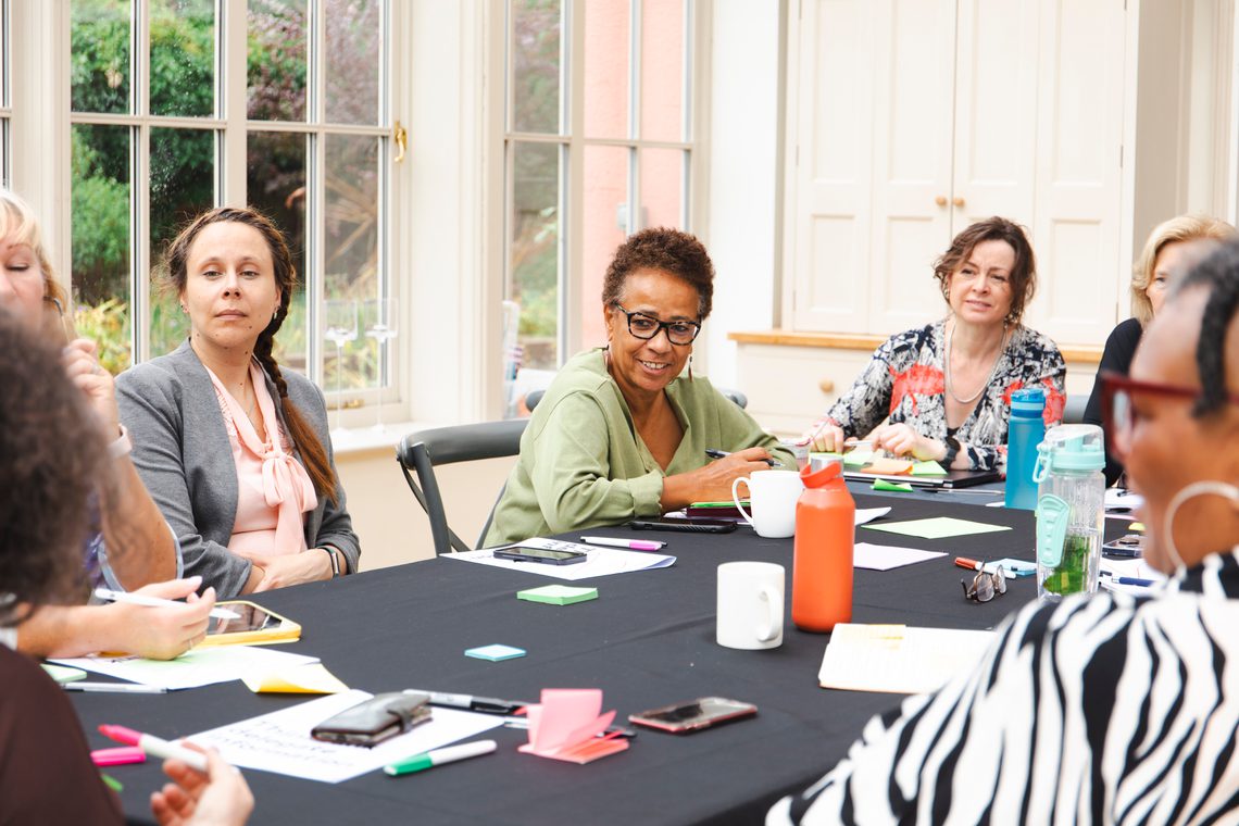 A group of people sitting at a table discussing.