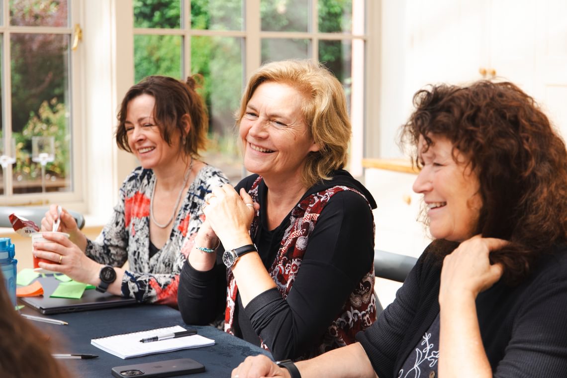 A group of people sitting at a table smiling.