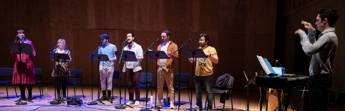 A group of people singong on stage