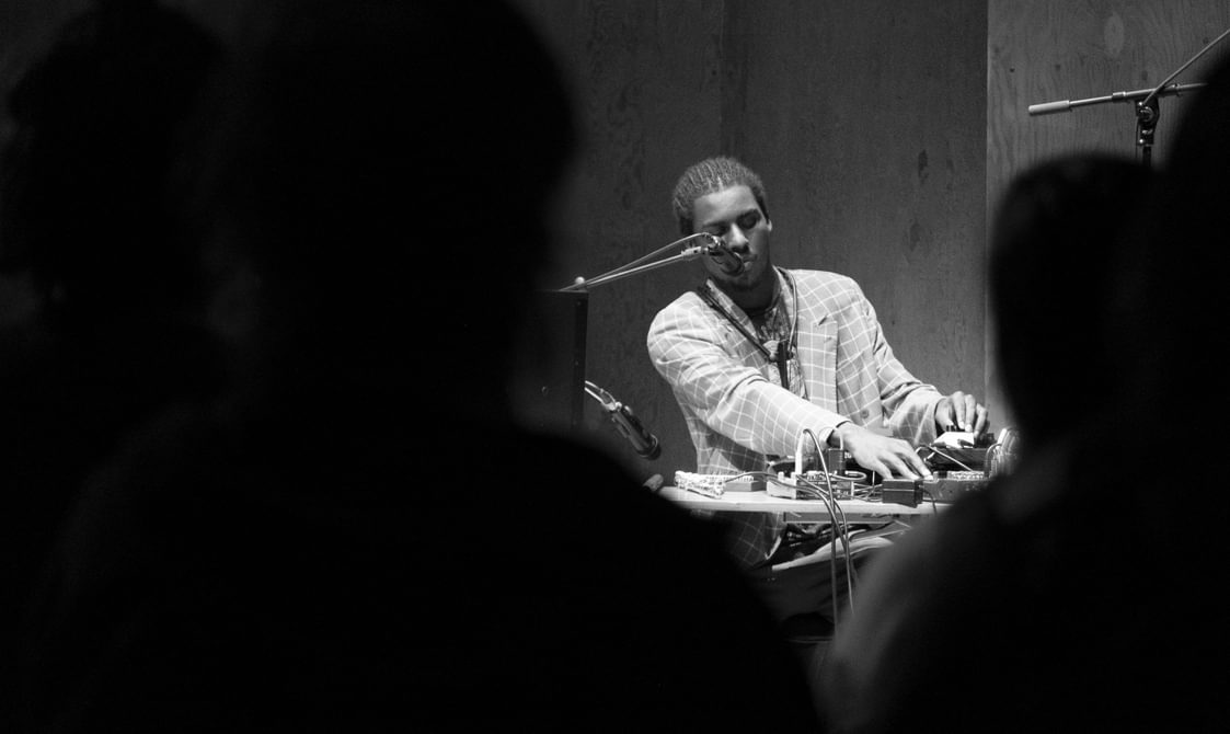 Man sat at a mixing desk with a mic